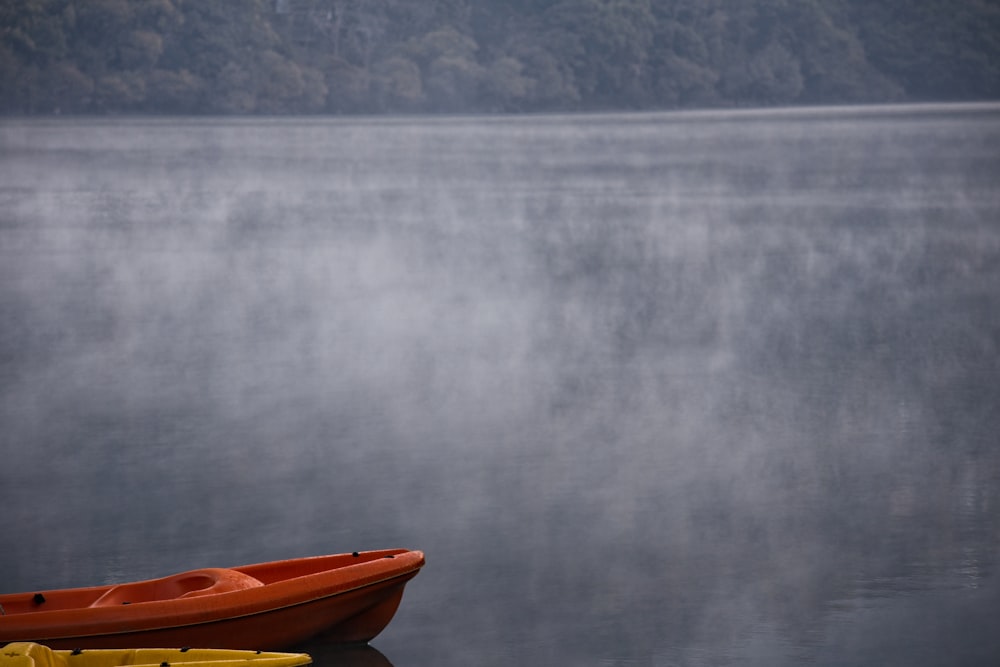 a red boat sitting on top of a body of water