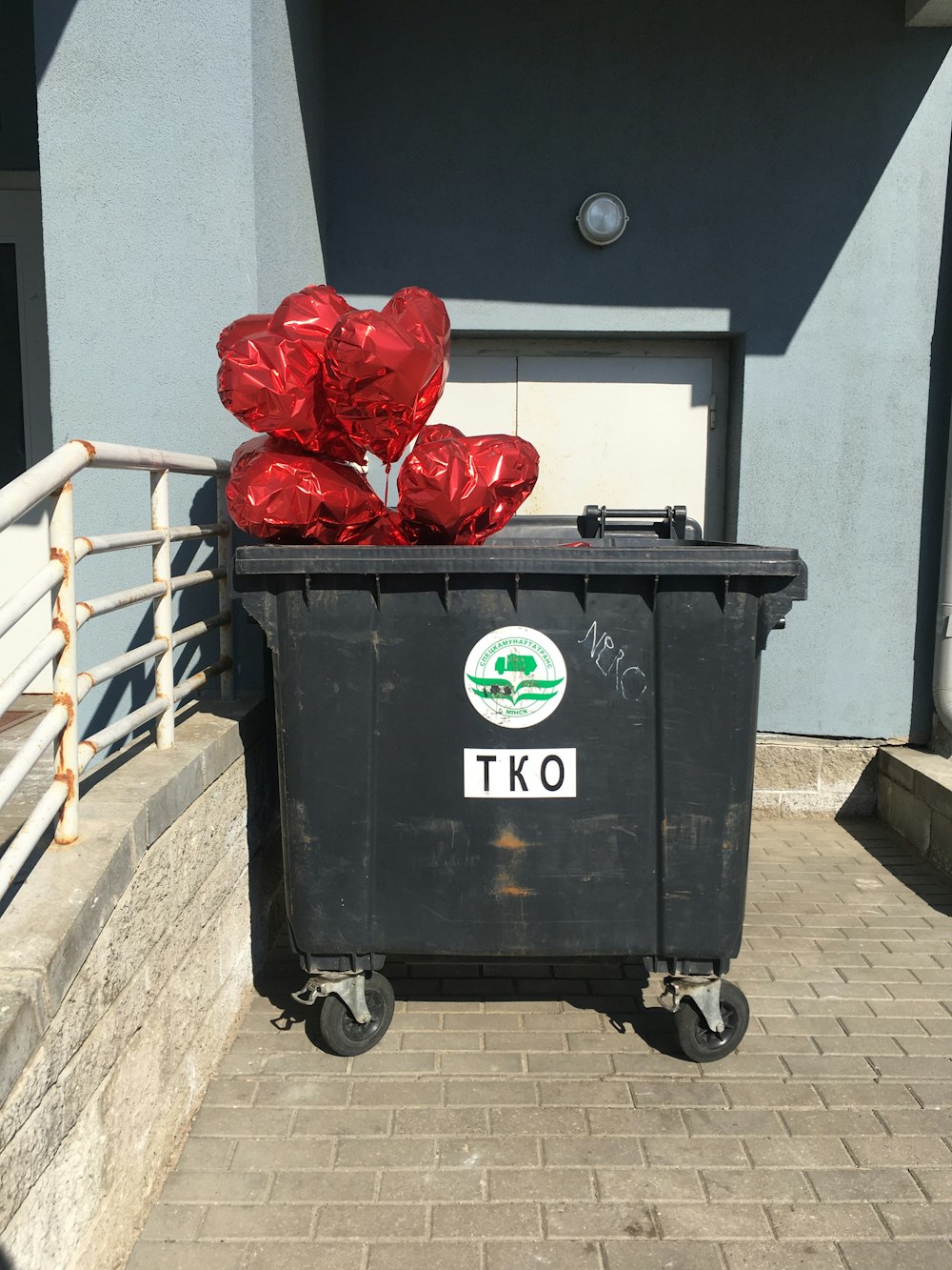 a black trash can with red foil wrapped around it