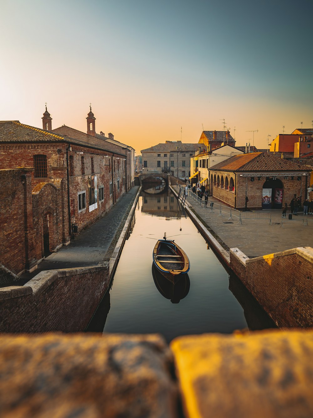 a small boat floating down a river next to buildings