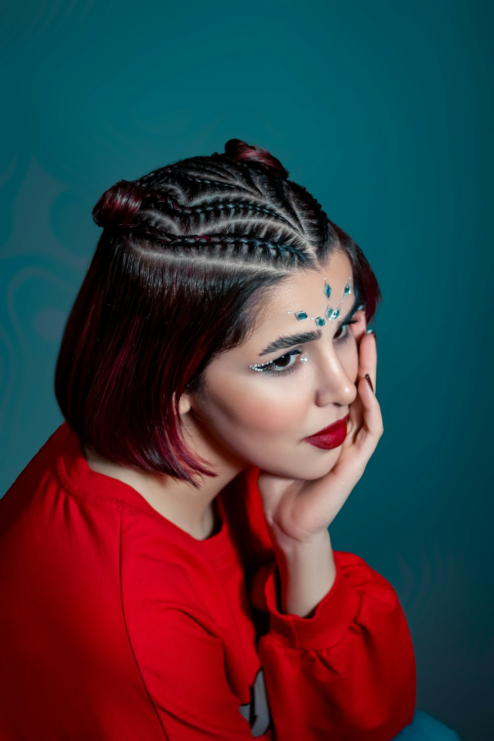 a woman in a red shirt with a braid on her head