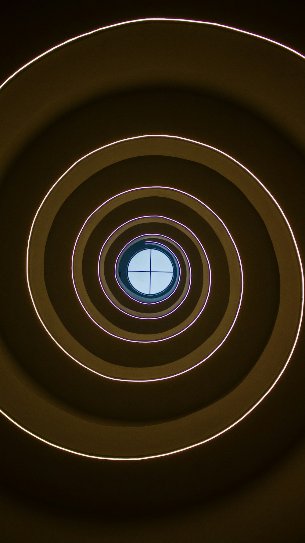 a circular light in a dark room with a window