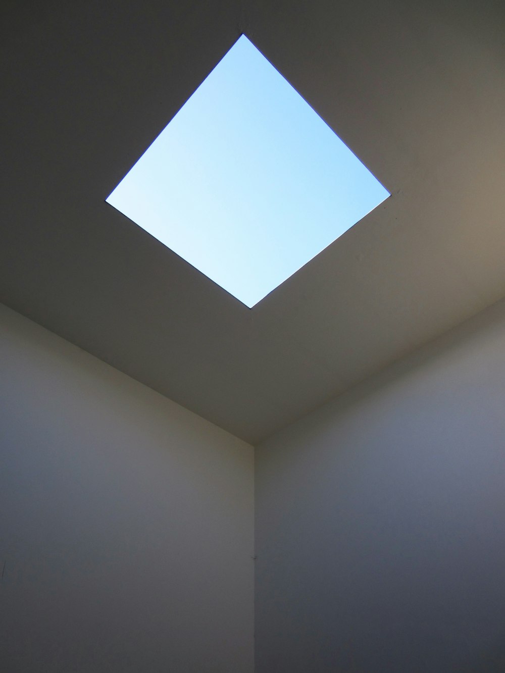 a white room with a skylight in the ceiling