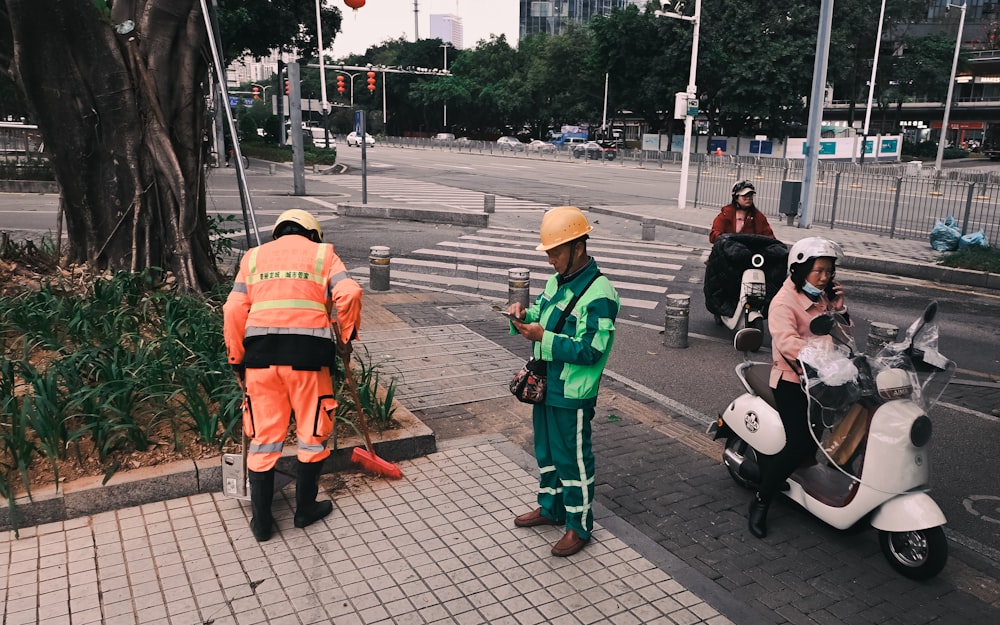 a group of people standing on the side of a road