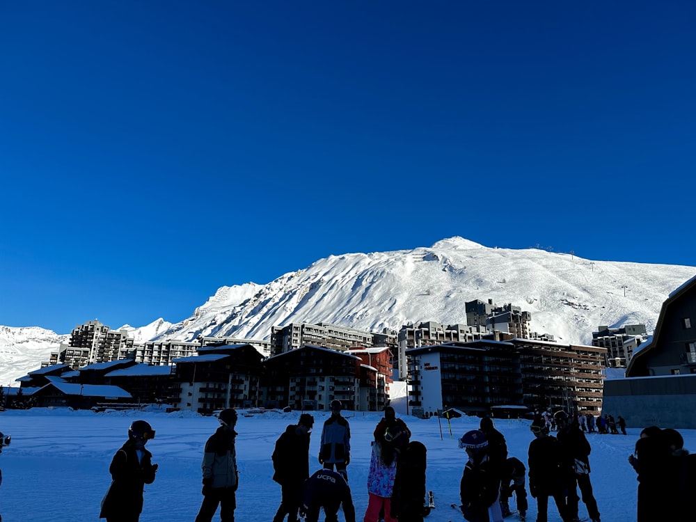 a group of people standing on top of a snow covered slope