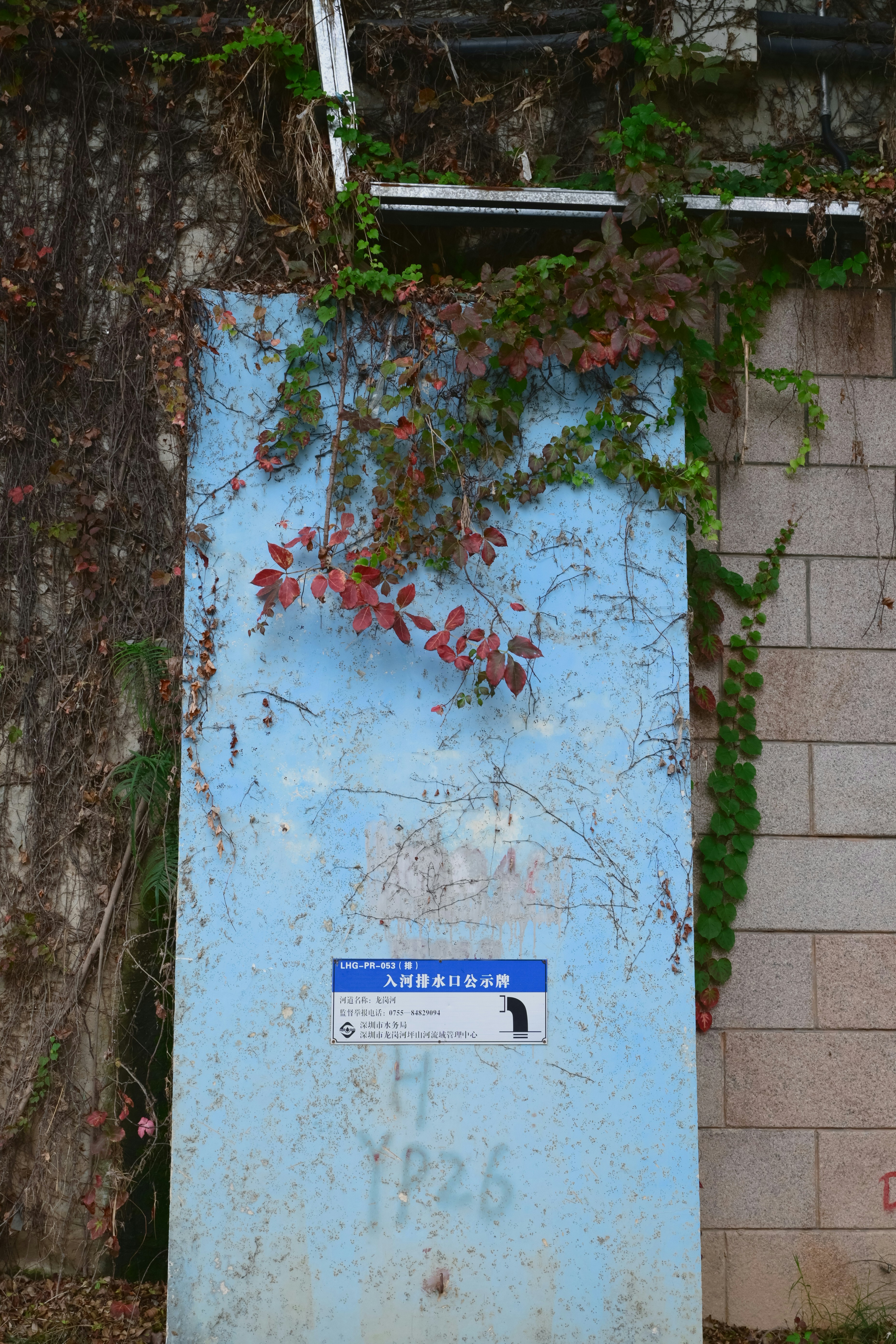 un panneau bleu posé à côté d’un mur de briques