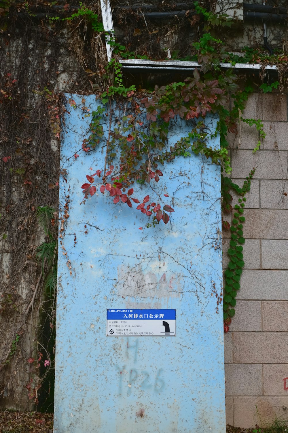 a blue sign sitting next to a brick wall