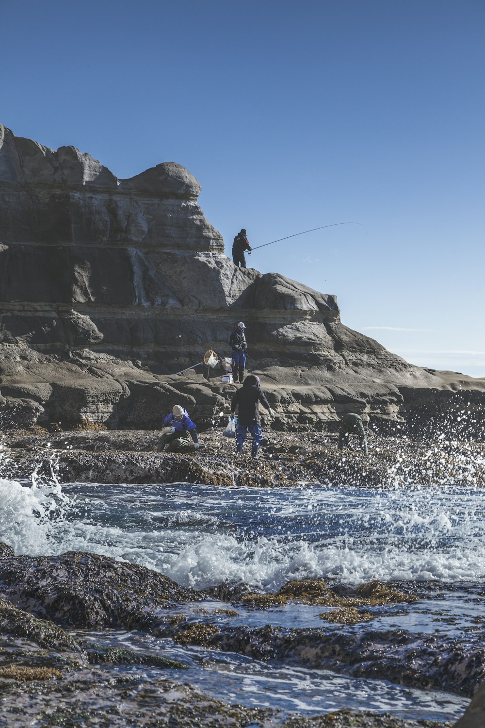 Un grupo de personas de pie en la cima de una playa rocosa