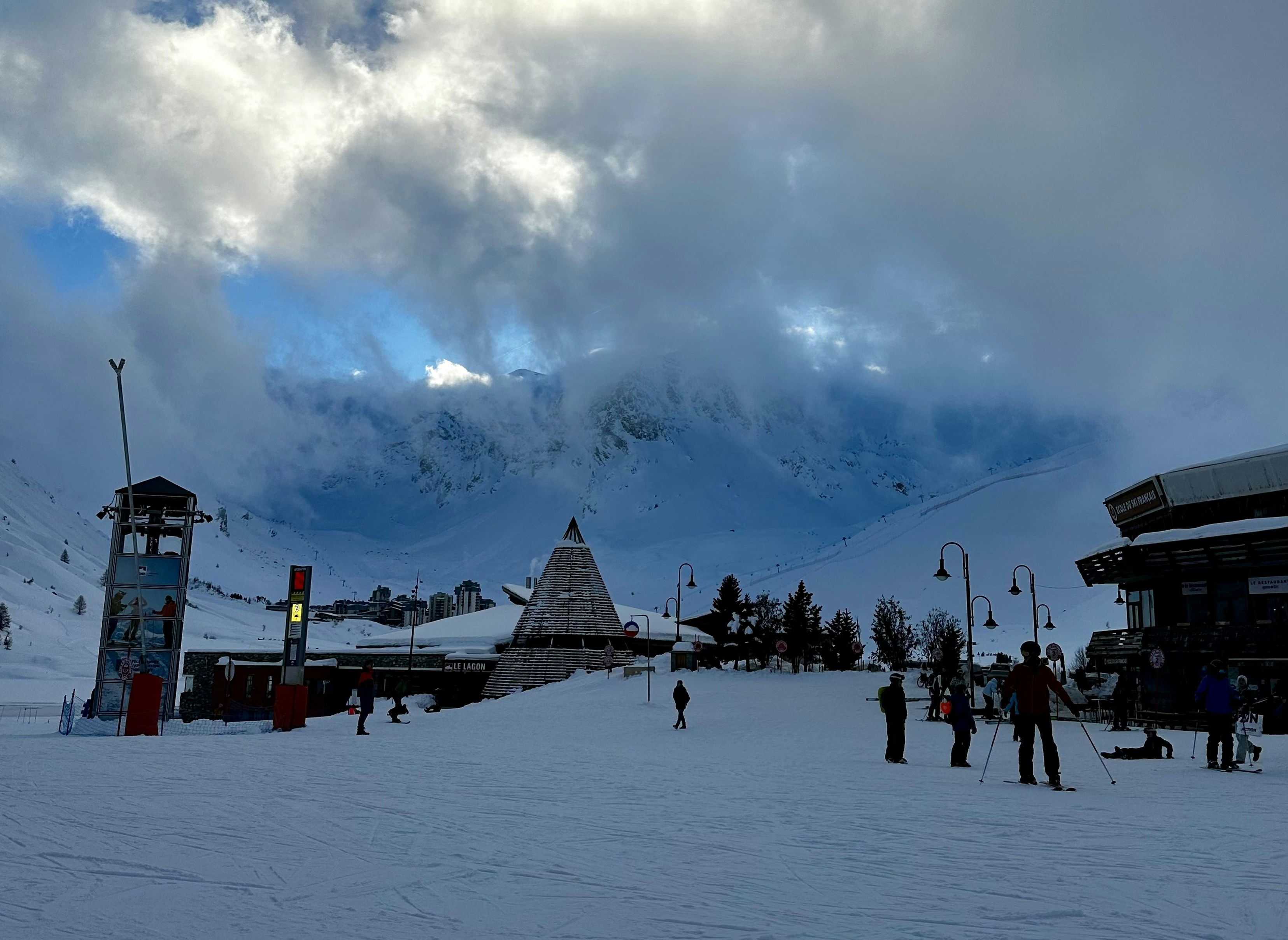 a group of people riding skis on top of a snow covered slope, 