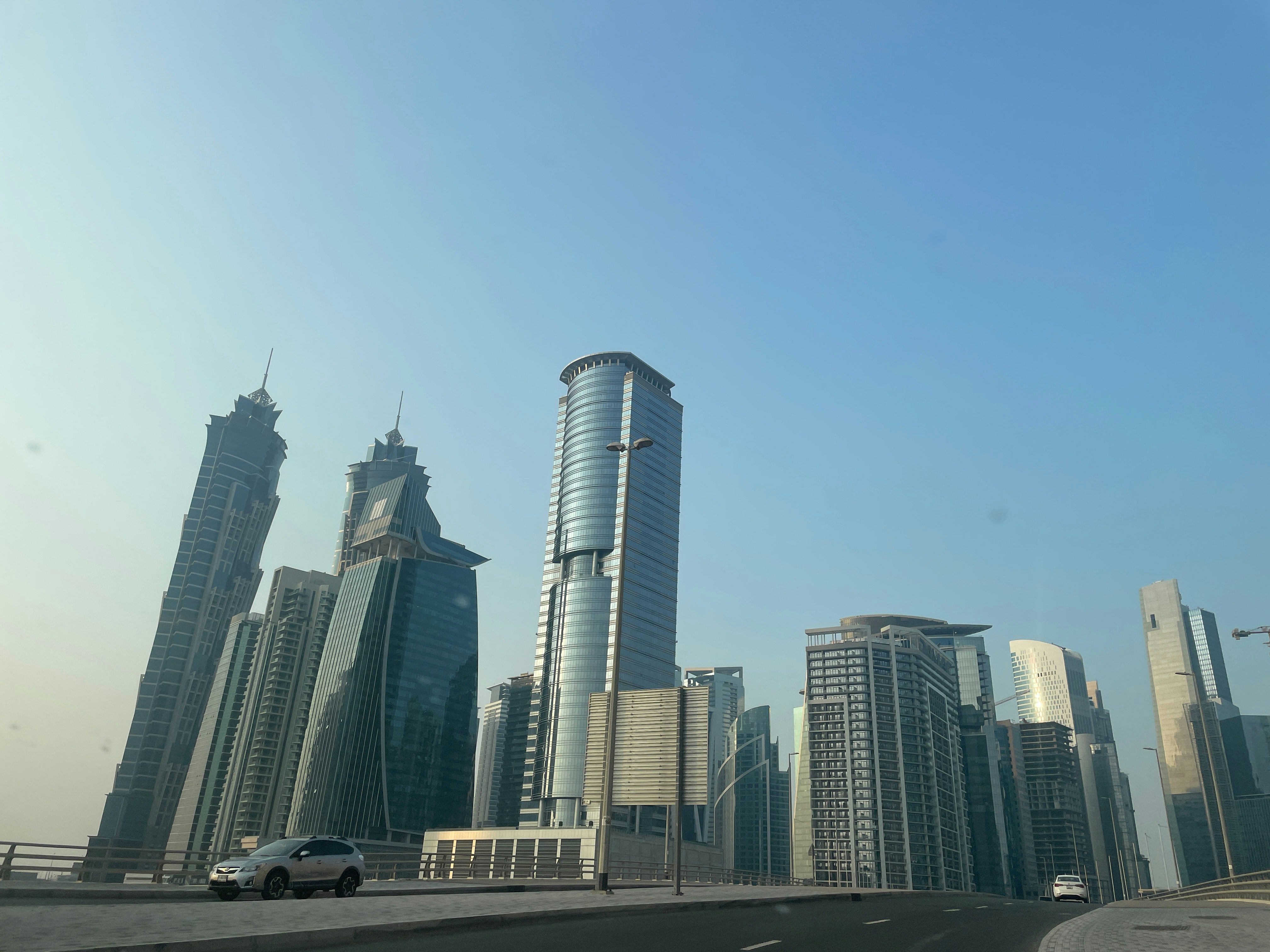 a car driving down a highway in front of tall buildings