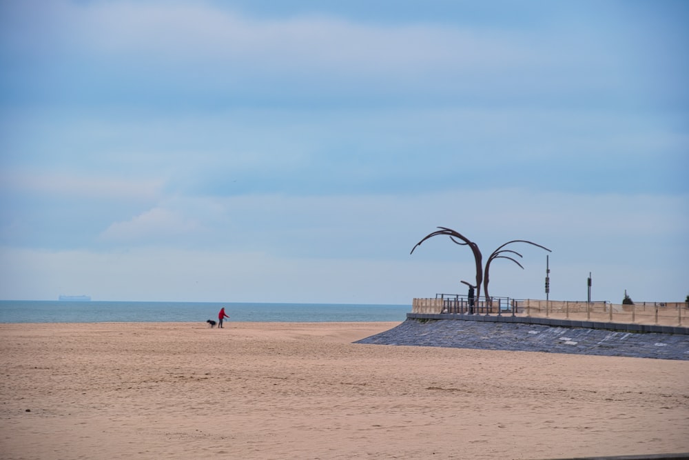 two people walking on a beach near the ocean