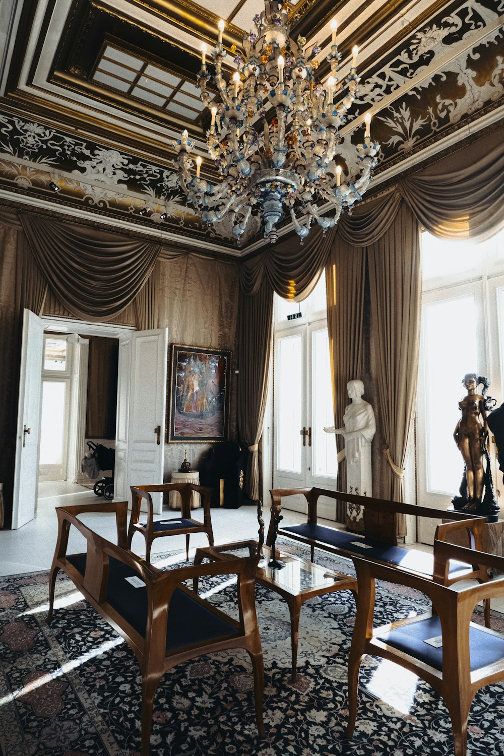 a living room with a chandelier a table and chairs