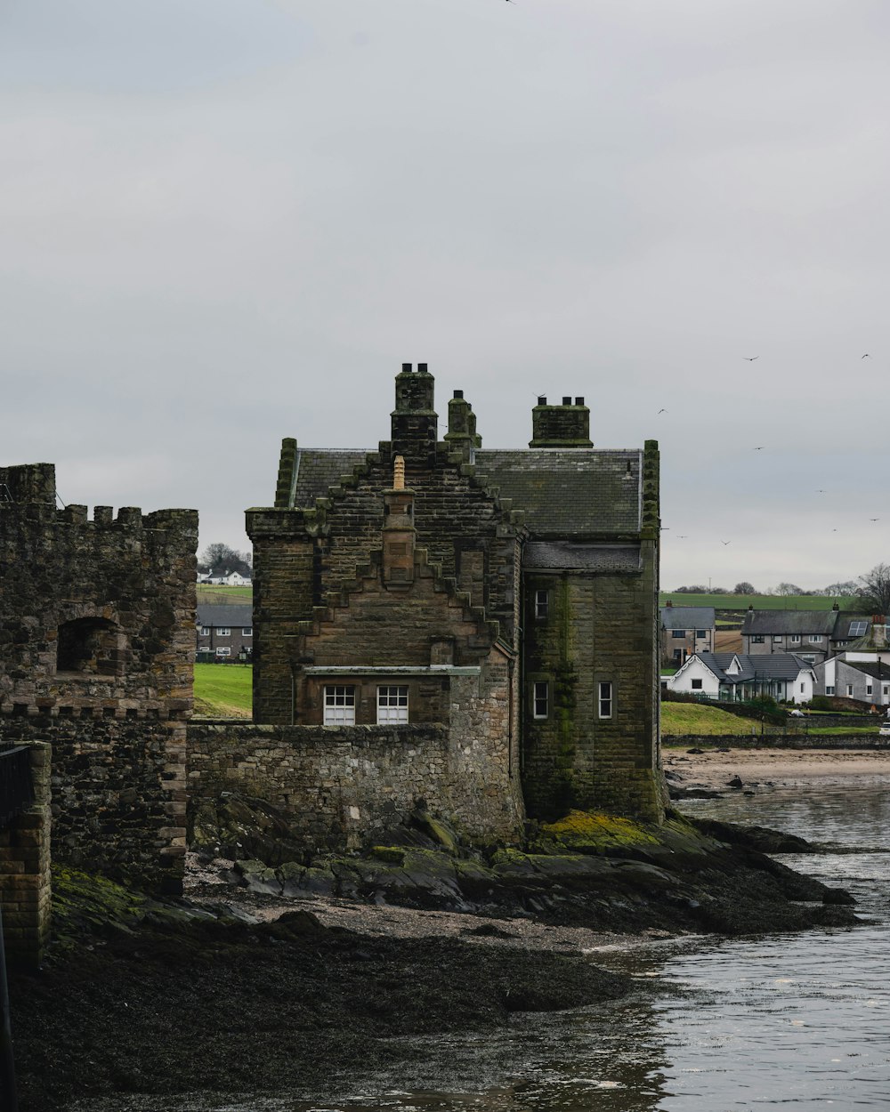 an old castle sitting on the shore of a lake