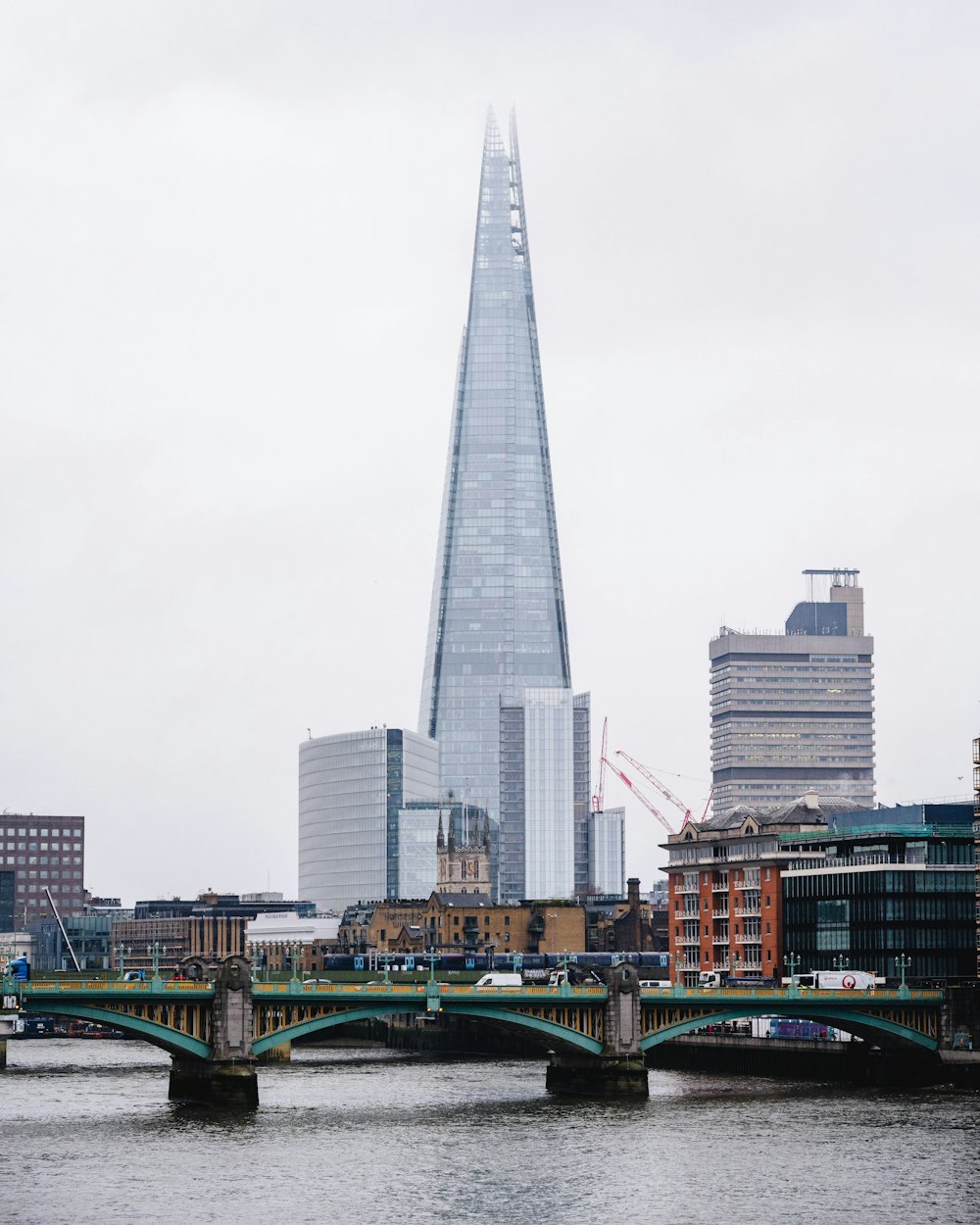 a view of a bridge with a very tall building in the background