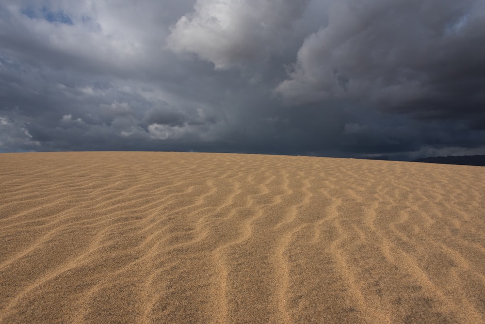 a large sand dune under a cloudy sky