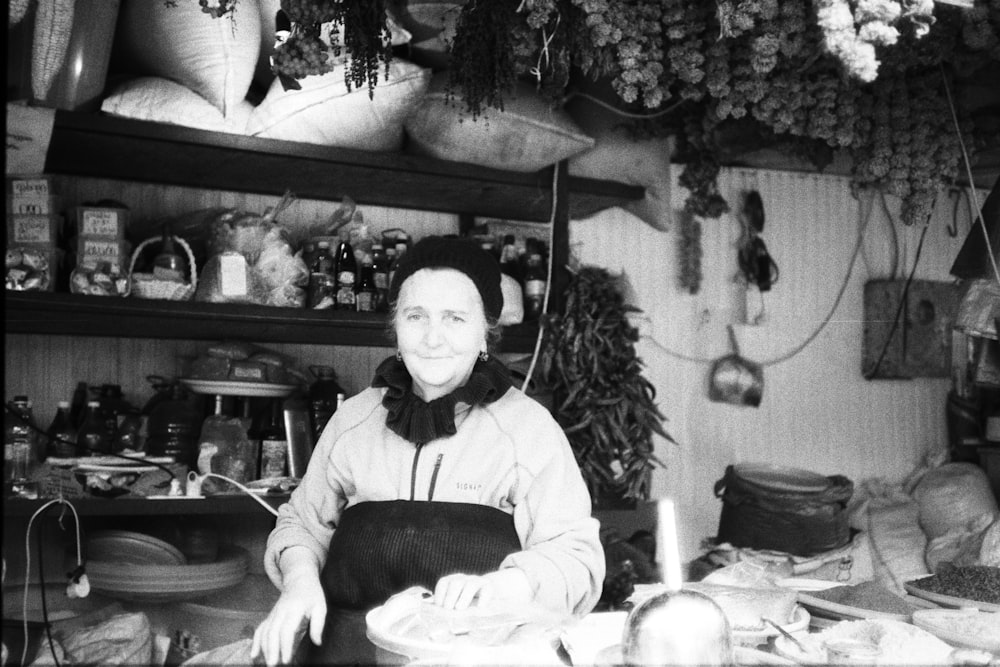 a black and white photo of a woman in a kitchen