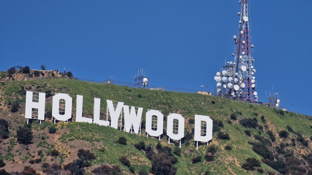 a hollywood sign on a hill with a radio tower in the background