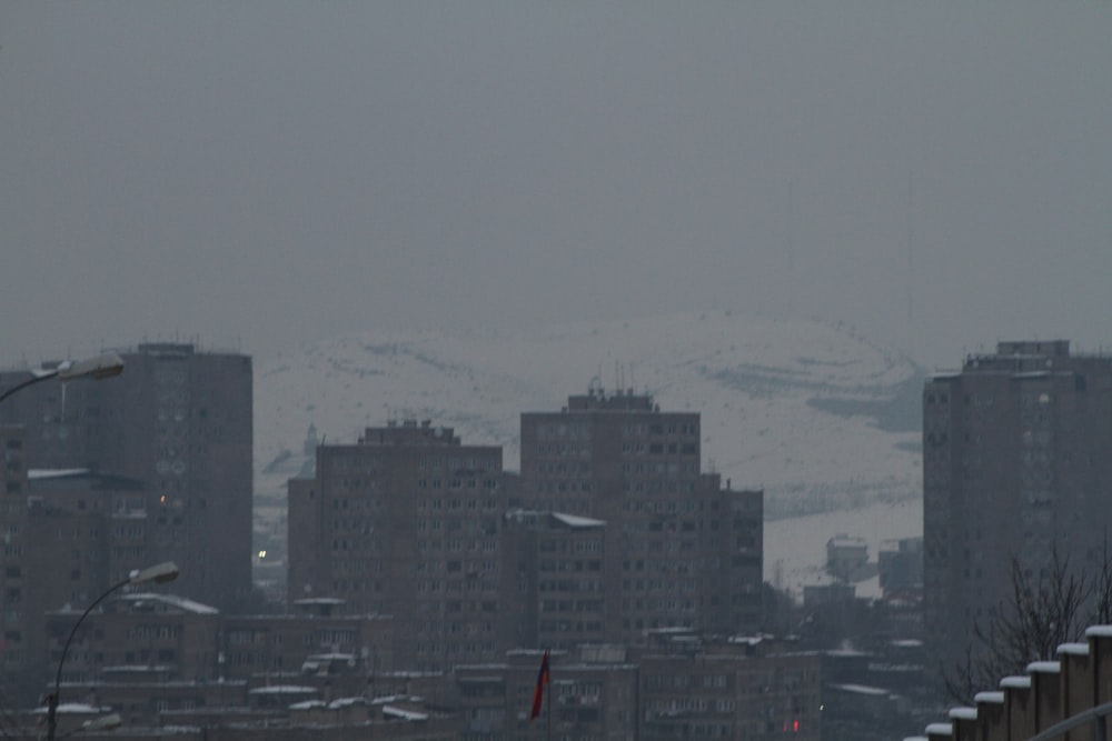 a view of a city with snow covered mountains in the background