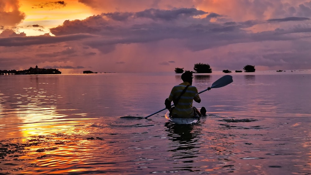 a person in a kayak paddling on the water