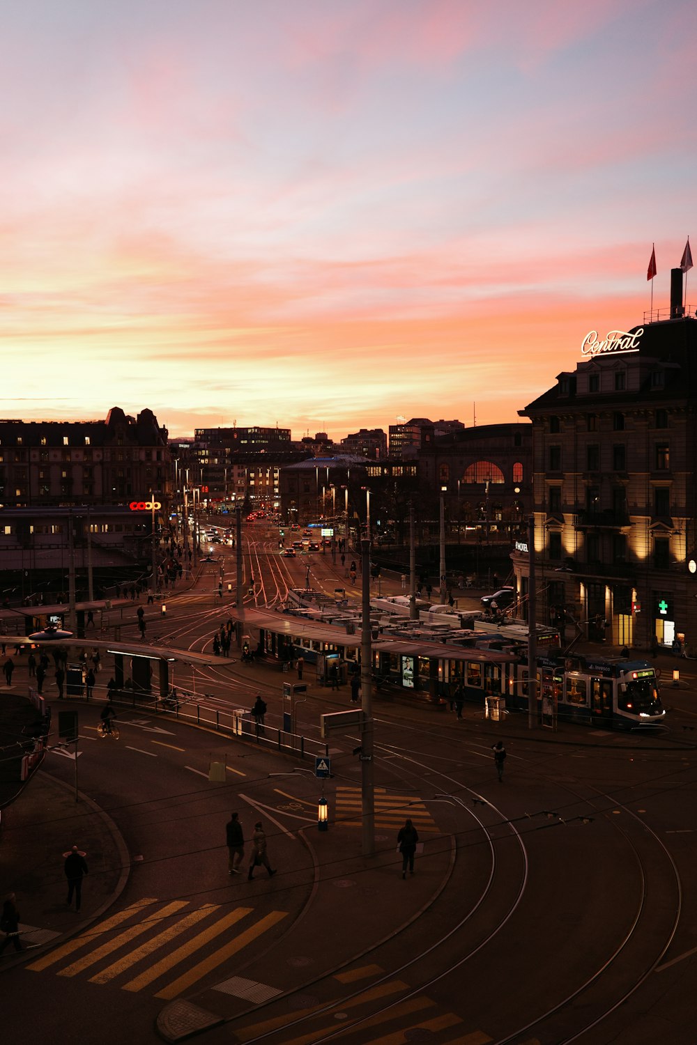 a sunset view of a city street with a train station in the background