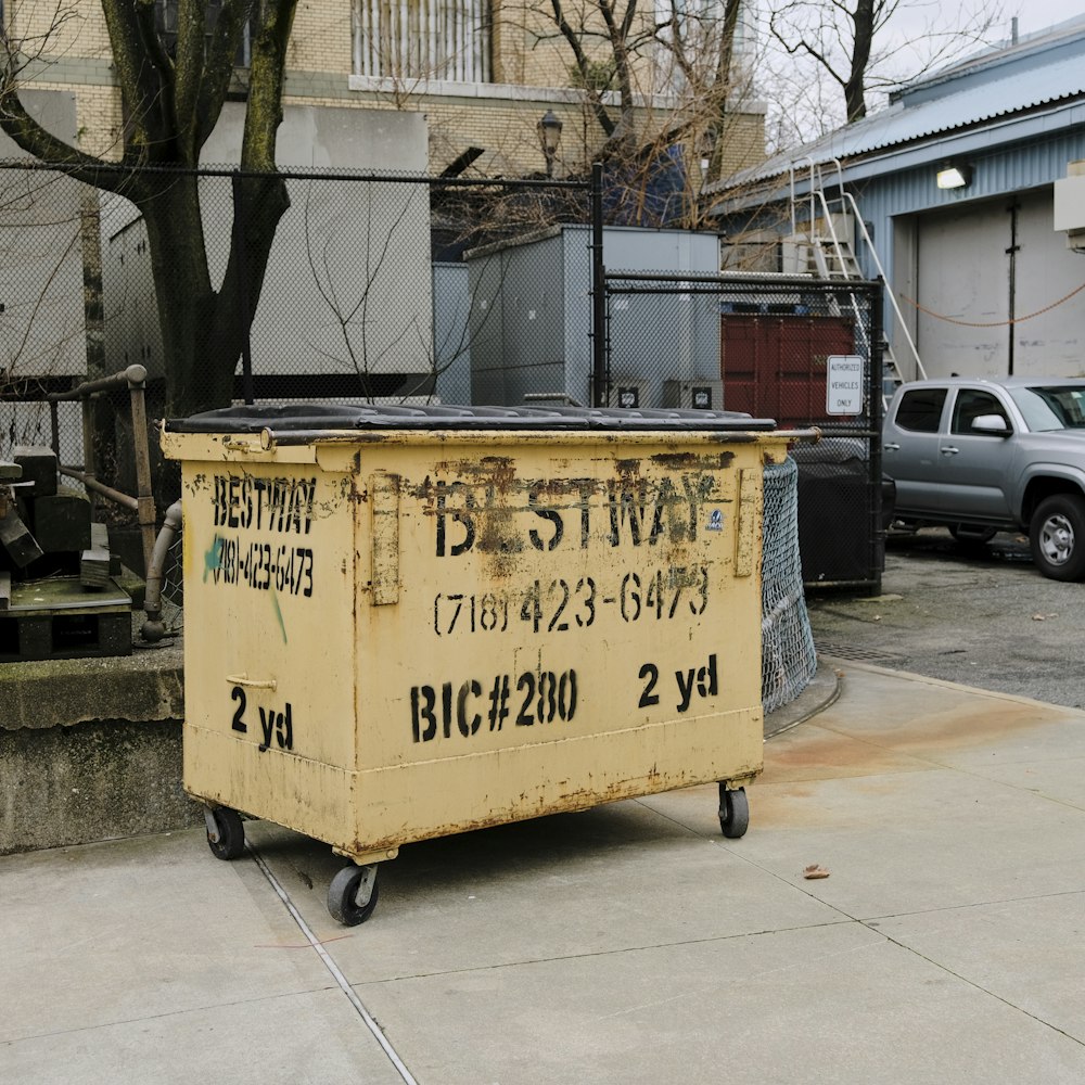 a yellow dumpster sitting on the side of a road