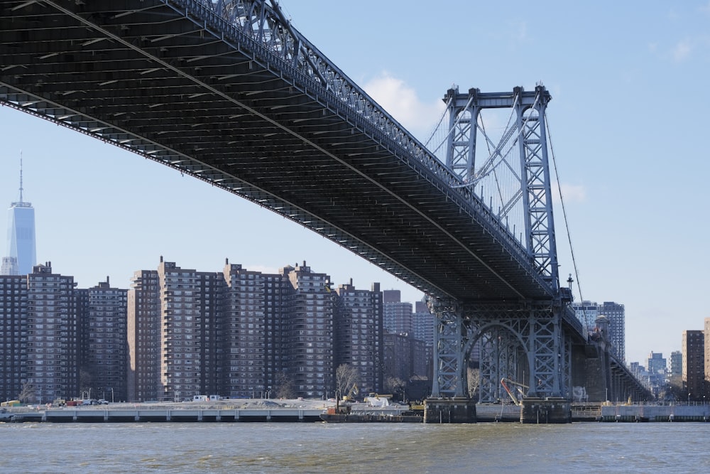 a bridge over a body of water with a city in the background