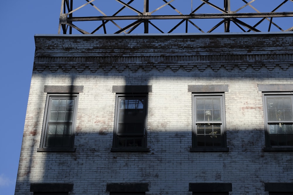 a tall brick building with windows and a sky background