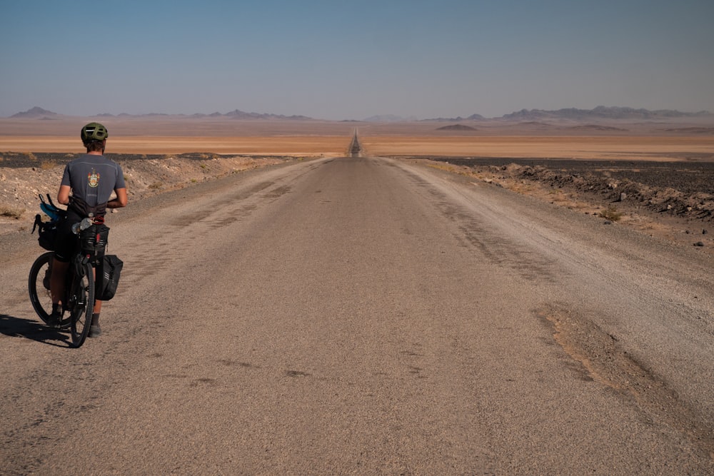 a man riding a bike down a dirt road