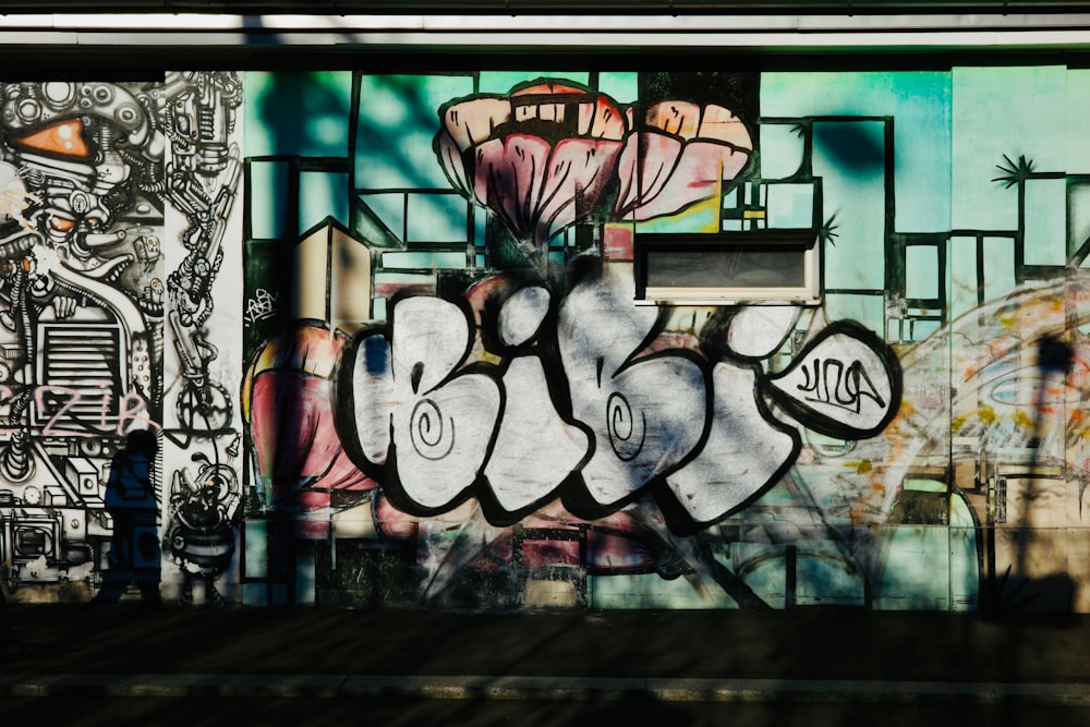 Ein Mann steht vor einer mit Graffiti beschmierten Wand