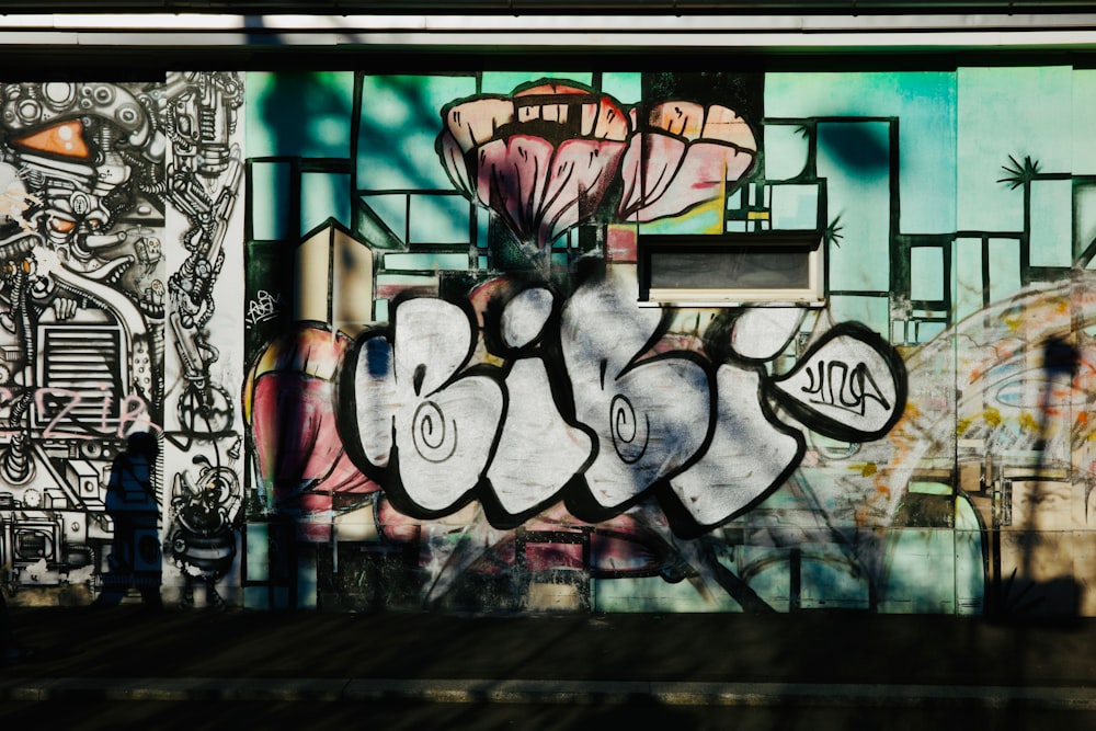 a man standing in front of a wall covered in graffiti