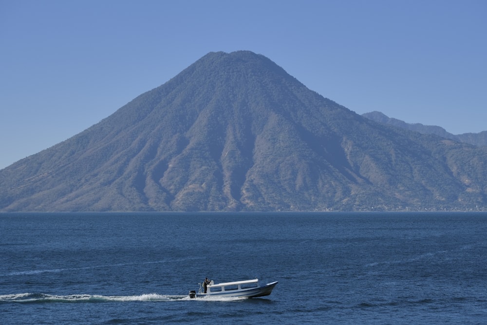 Un barco en el agua con una montaña al fondo