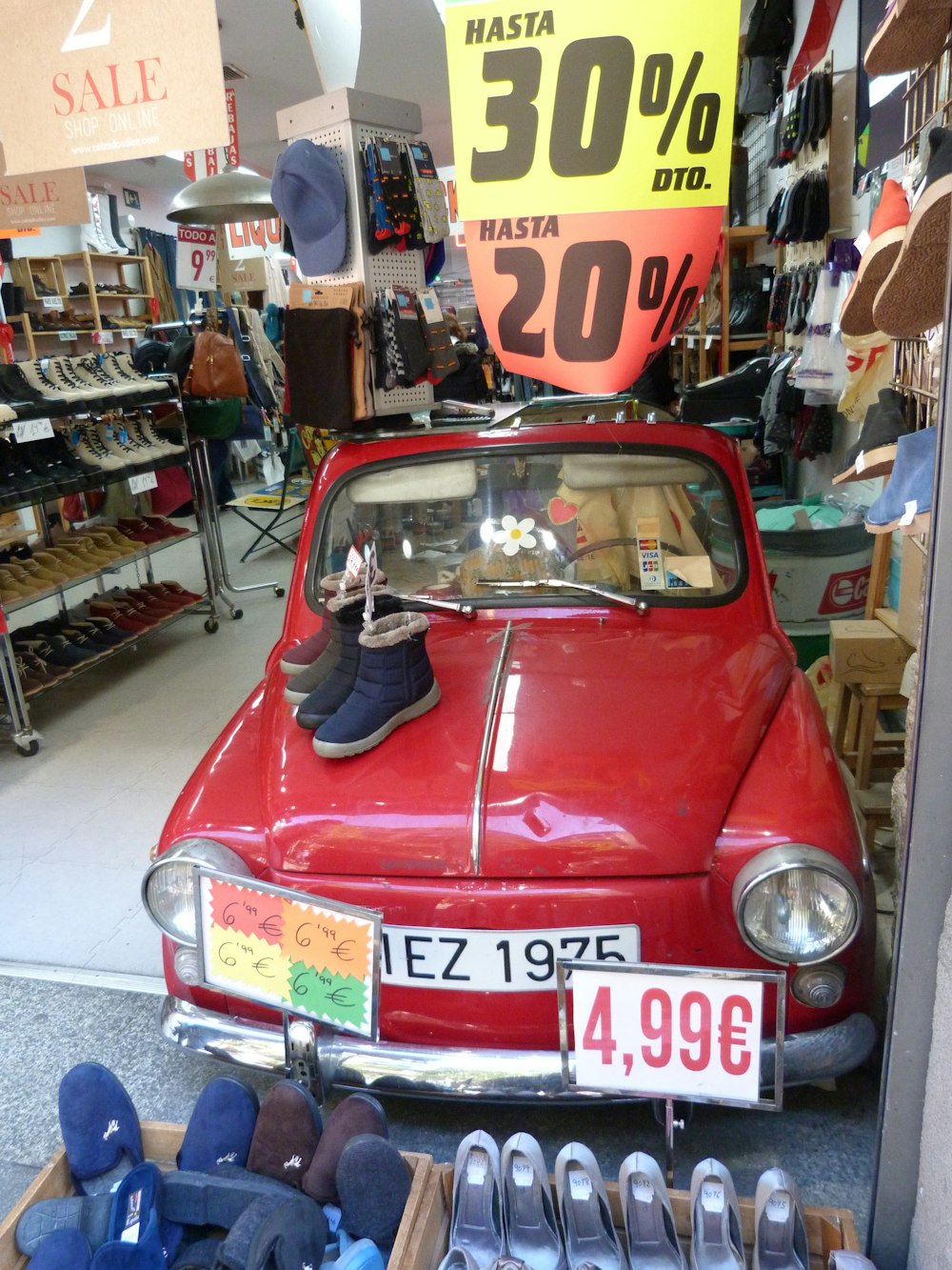 a red car is parked in a shoe store