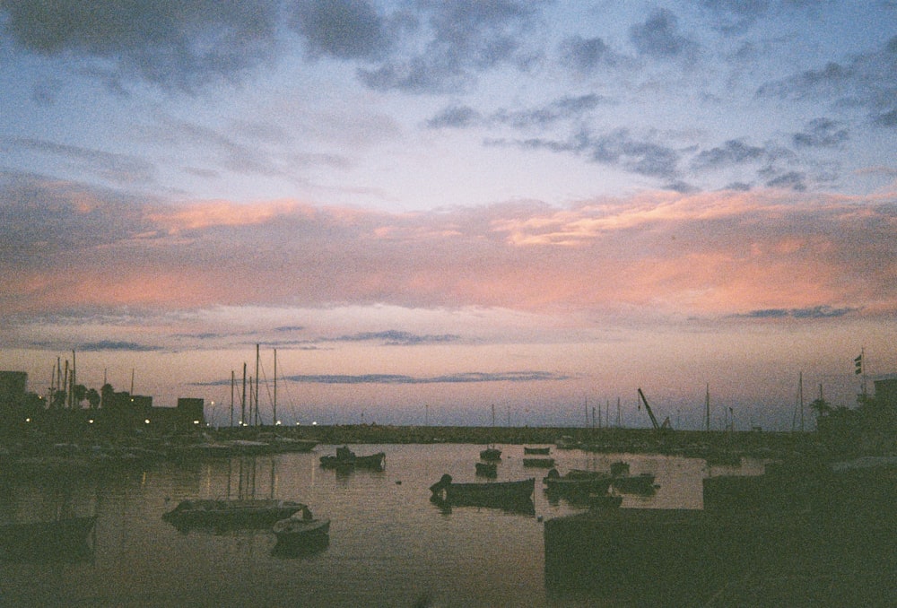 a harbor filled with lots of boats under a cloudy sky