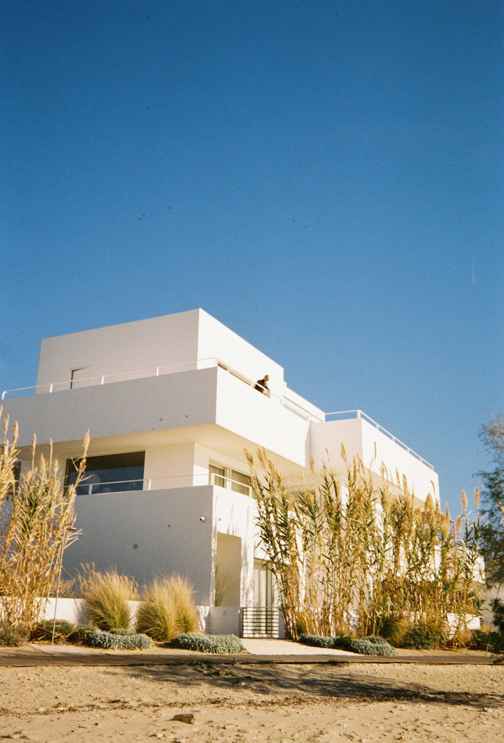 a large white building sitting on top of a sandy beach