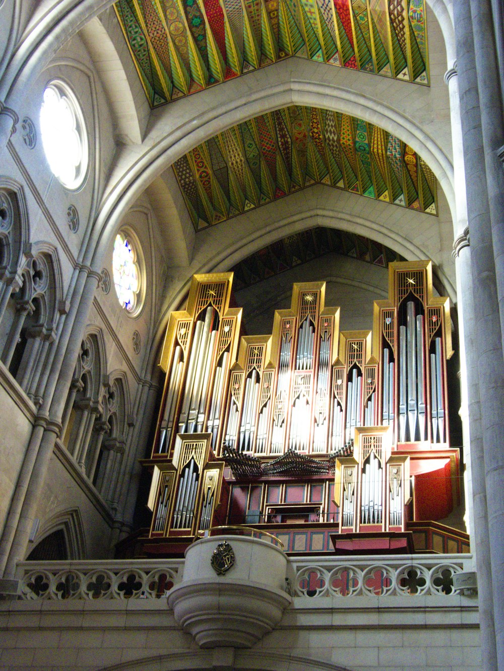 a large pipe organ in a church with stained glass windows