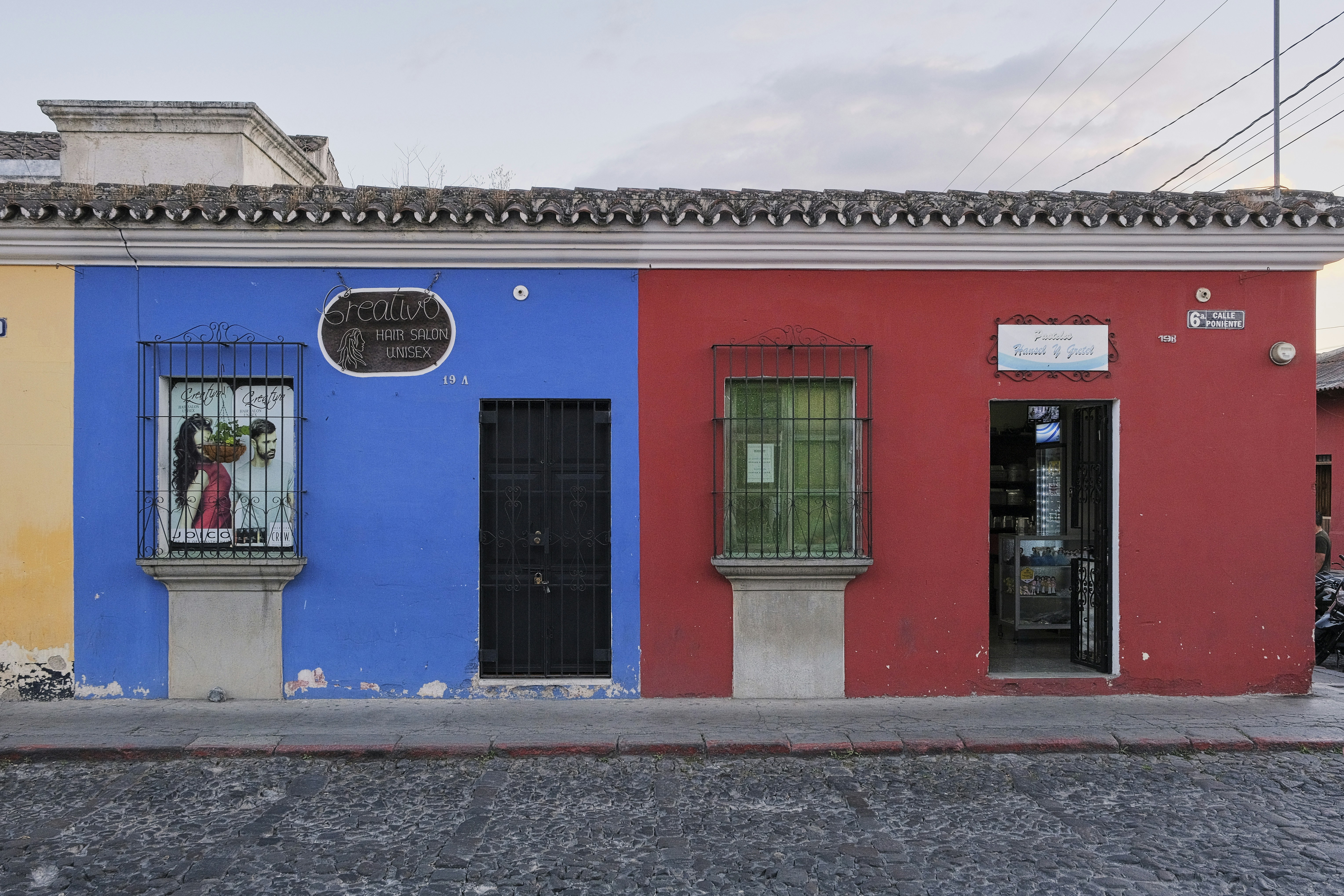 Una escena callejera con un edificio pintado de diferentes colores