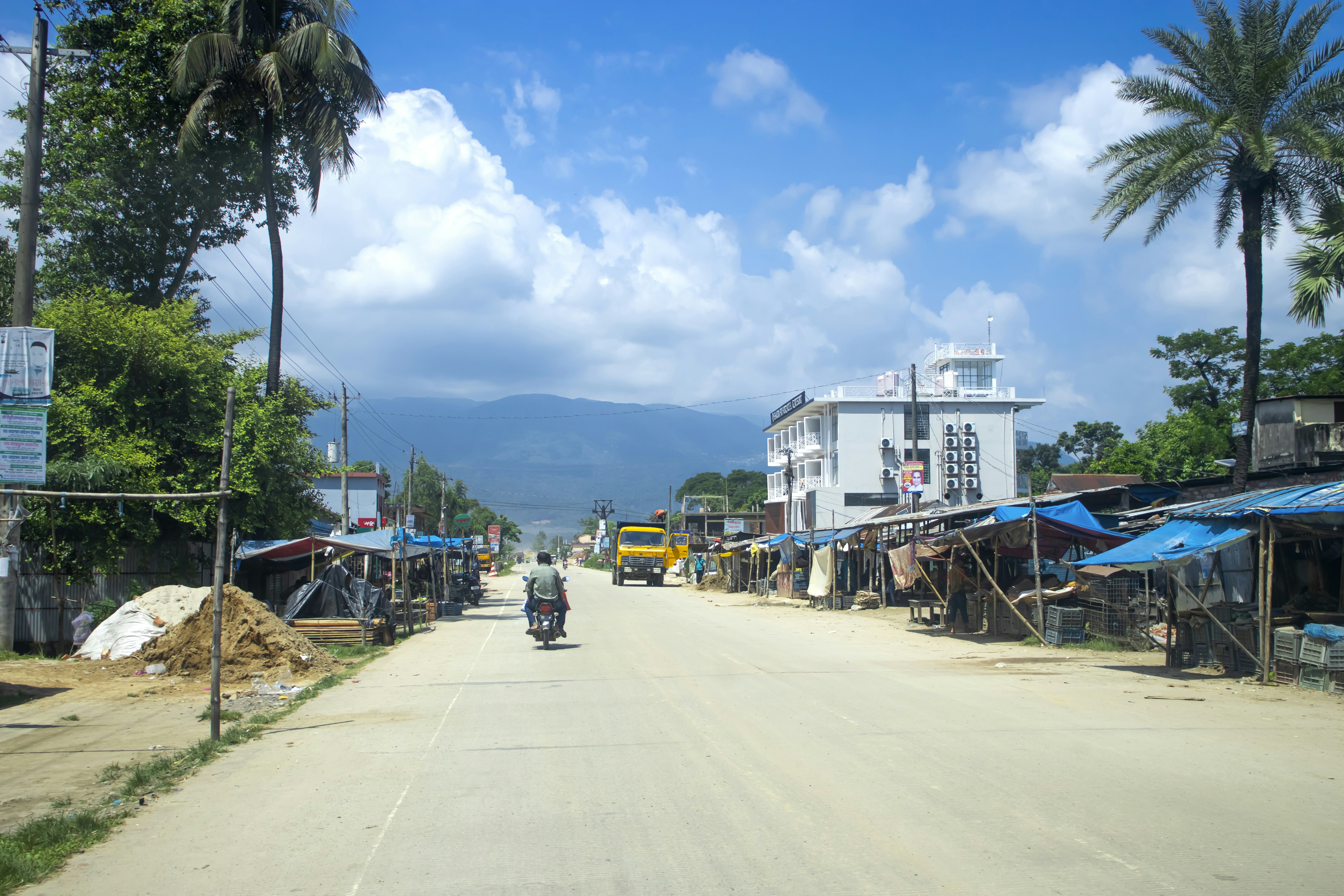 a man riding a motorcycle down a dirt road