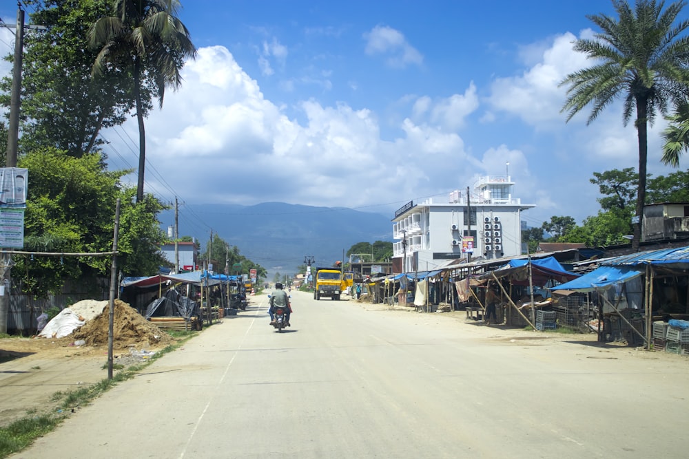 a man riding a motorcycle down a dirt road