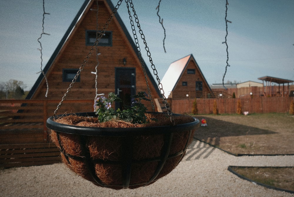 a hanging planter filled with plants in front of a house