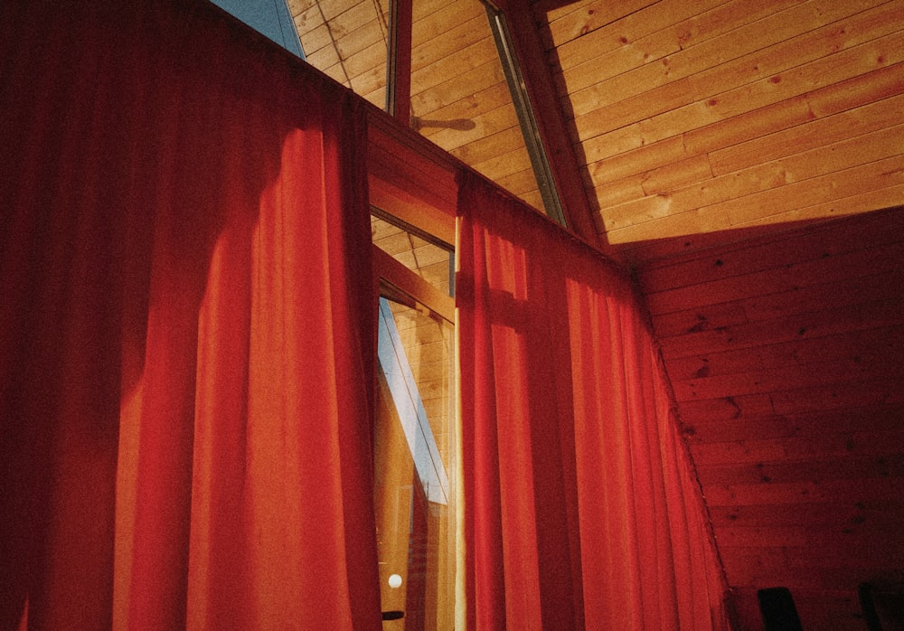 a room with a red curtain and a ceiling fan