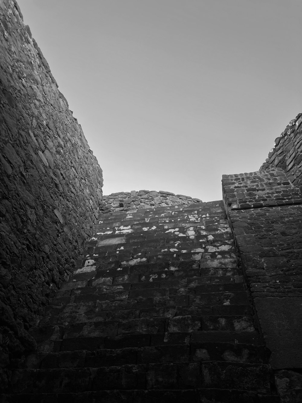 uma foto em preto e branco de uma parede de pedra