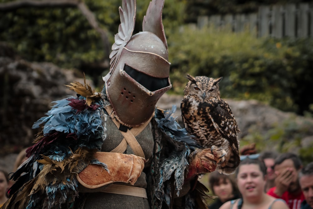 a person in a costume with an owl on his arm