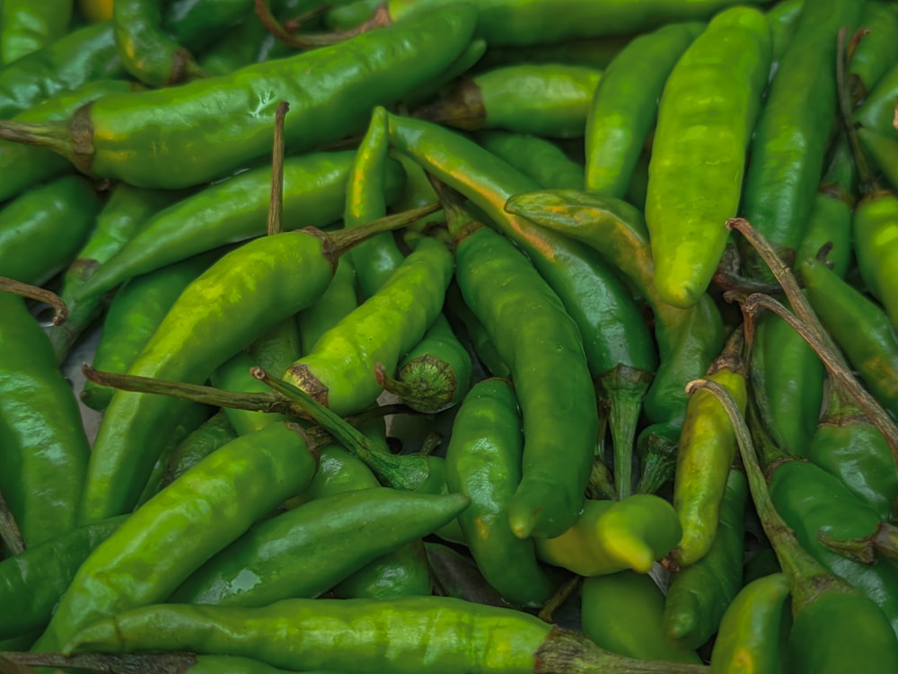 a pile of green peppers sitting next to each other