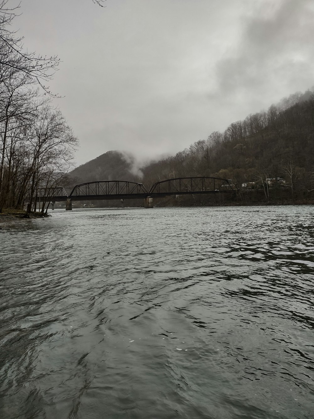 a bridge over a body of water with a mountain in the background