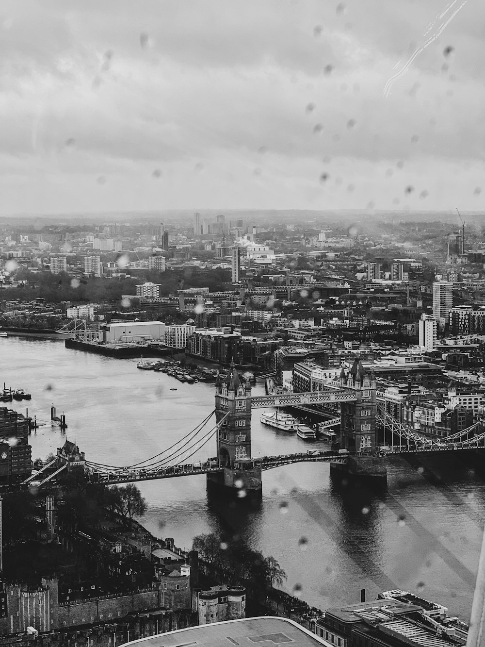 a black and white photo of a city with a bridge