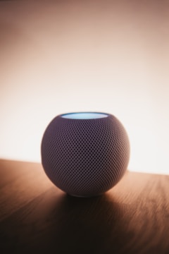 a bluetooth speaker sitting on top of a wooden table