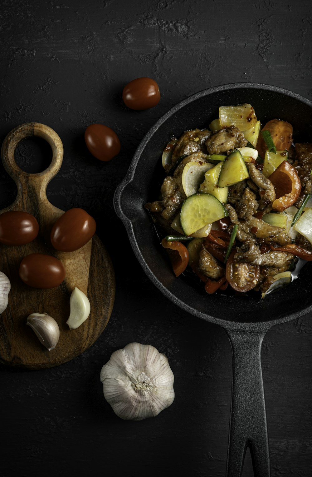 a pan filled with meat and vegetables next to garlic