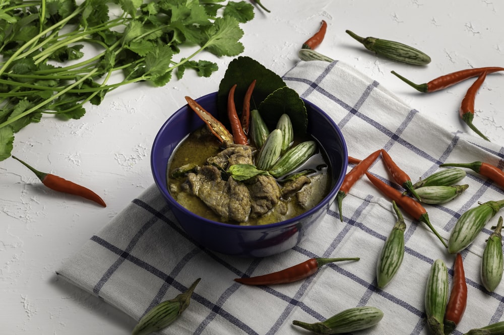 a blue bowl filled with meat and vegetables