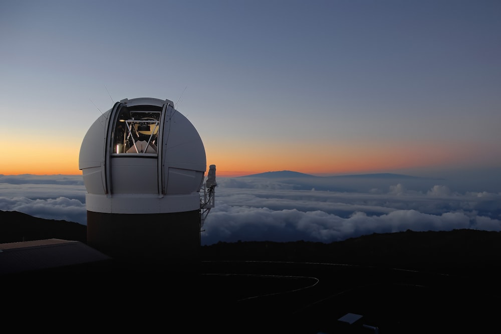 a telescope sitting on top of a mountain above the clouds