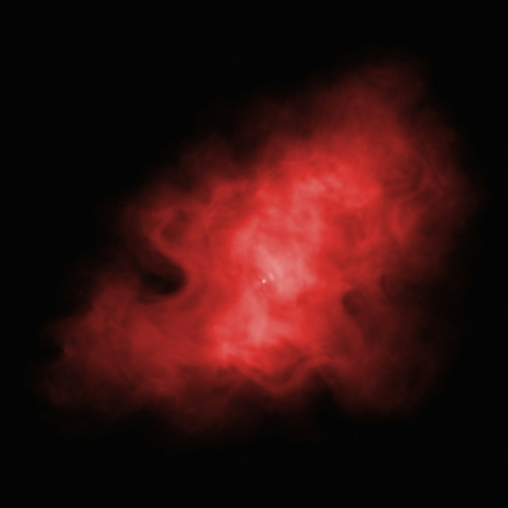 a red cloud of smoke on a black background