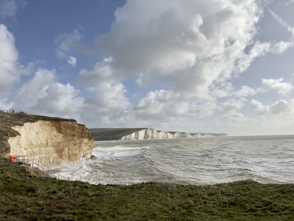 a view of a beach with a cliff in the background